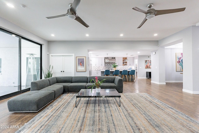 living room with ceiling fan and hardwood / wood-style floors