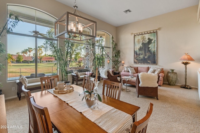 dining room featuring ceiling fan with notable chandelier, carpet flooring, and plenty of natural light