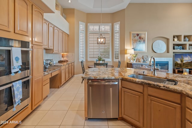 kitchen featuring pendant lighting, stainless steel appliances, light tile patterned floors, sink, and light stone countertops