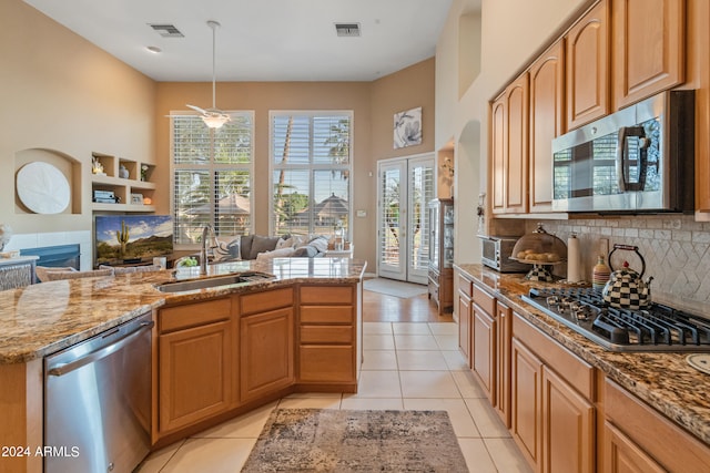 kitchen with light tile patterned floors, decorative light fixtures, stainless steel appliances, sink, and ceiling fan