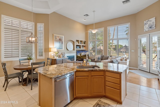 kitchen with light stone counters, light hardwood / wood-style floors, a notable chandelier, sink, and stainless steel dishwasher