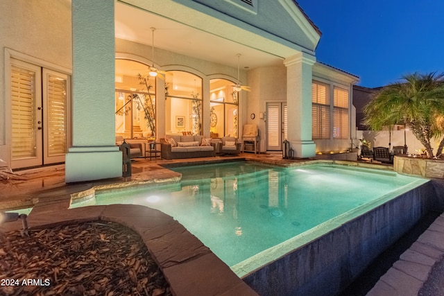 pool at night featuring french doors, a patio, and outdoor lounge area