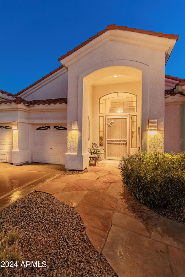 exterior entry at night with a garage