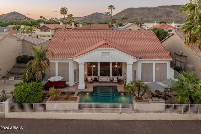 exterior space with a mountain view, an outdoor hangout area, a patio area, and a fenced in pool