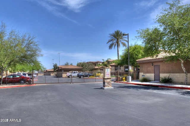 view of street with a residential view, a gated entry, curbs, and a gate