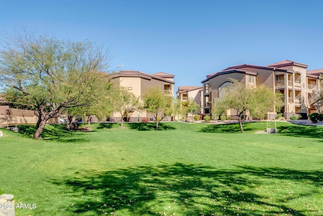 view of property's community with a residential view and a lawn