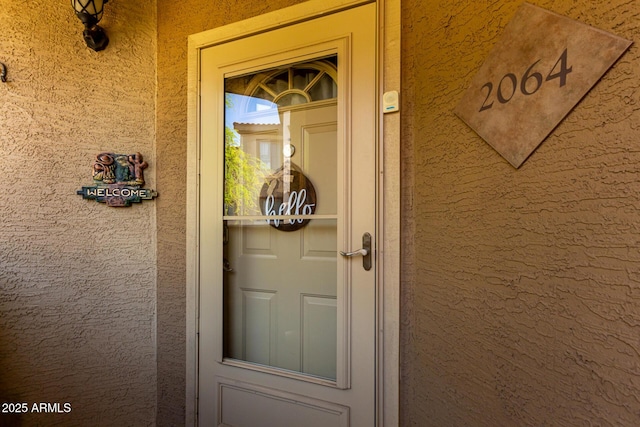 entrance to property with stucco siding