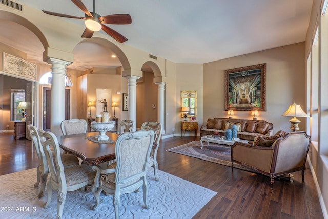 dining space featuring decorative columns, ceiling fan, and dark wood-type flooring