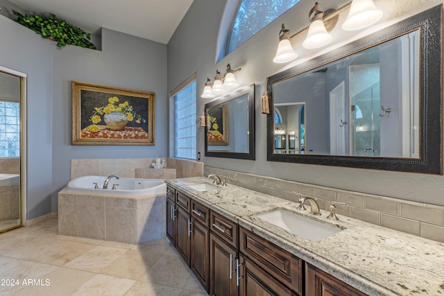 bathroom featuring shower with separate bathtub, vanity, and tile patterned floors