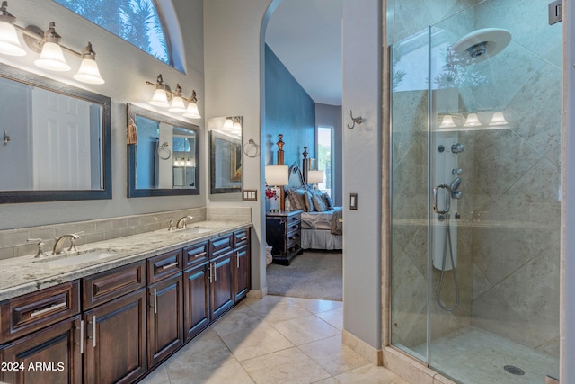 bathroom with decorative backsplash, vanity, tile patterned floors, and a shower with door