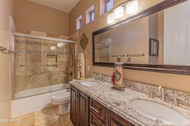 full bathroom featuring shower / bath combination with glass door, tile patterned flooring, vanity, and toilet