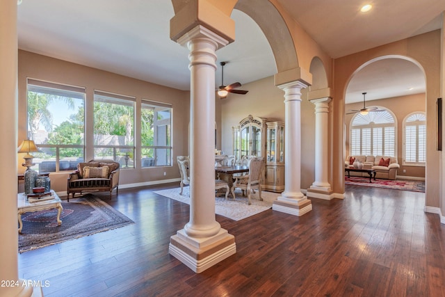 living room with a wealth of natural light, ceiling fan, and dark wood-type flooring