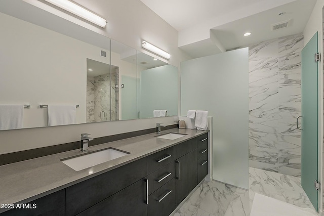 full bath with a sink, a marble finish shower, marble finish floor, and visible vents