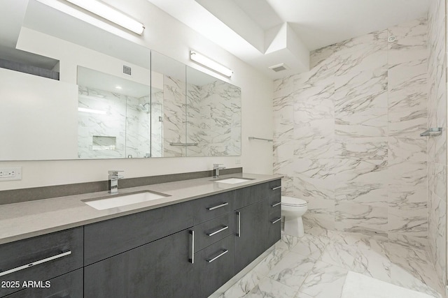 full bath featuring a marble finish shower, visible vents, toilet, and a sink