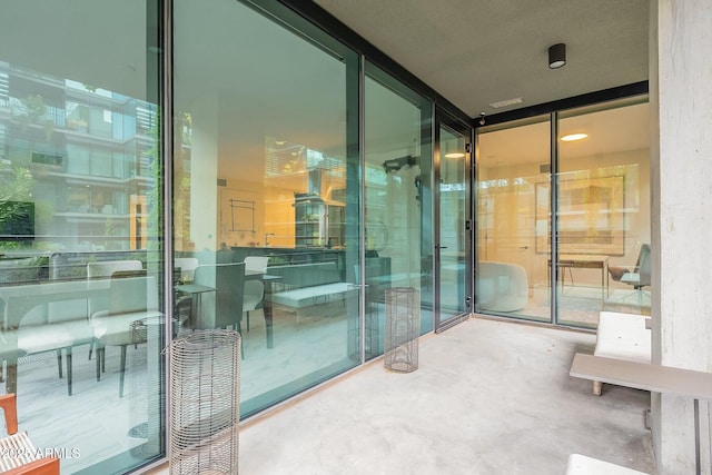 exterior space with floor to ceiling windows and concrete floors