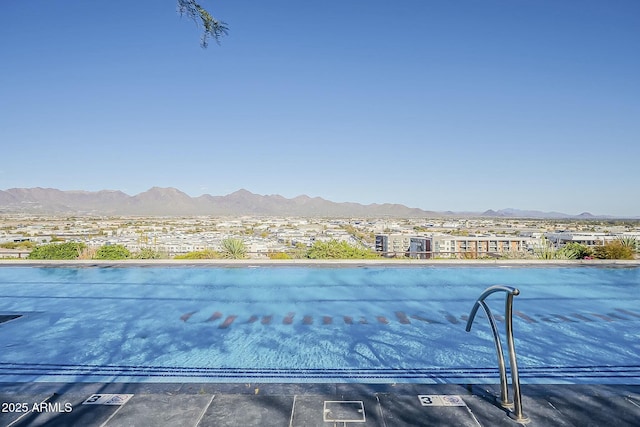 view of swimming pool with a mountain view