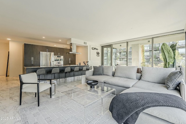 living area with recessed lighting and marble finish floor