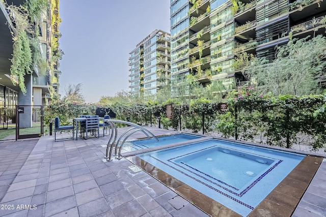 view of swimming pool featuring a patio area, outdoor dining space, and fence