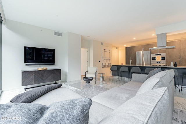 living area with recessed lighting, visible vents, and marble finish floor