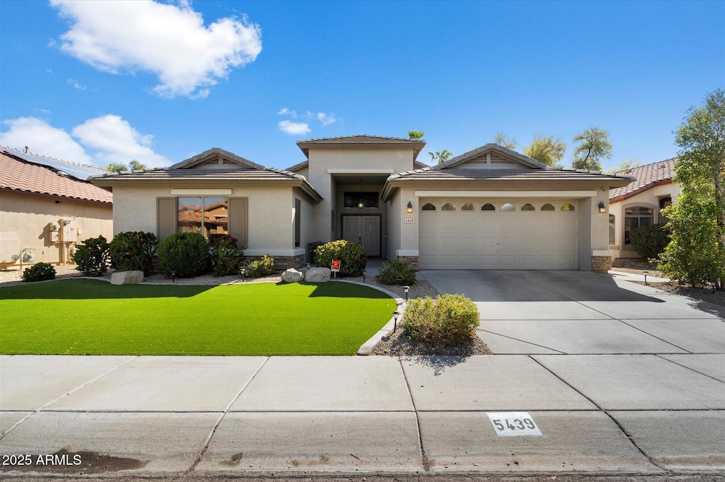 view of front facade featuring concrete driveway, a garage, a front lawn, and stucco siding