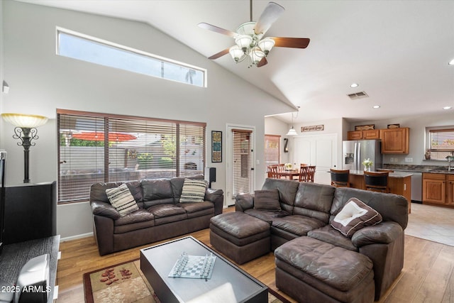 living area with a ceiling fan, visible vents, high vaulted ceiling, recessed lighting, and light wood-style floors