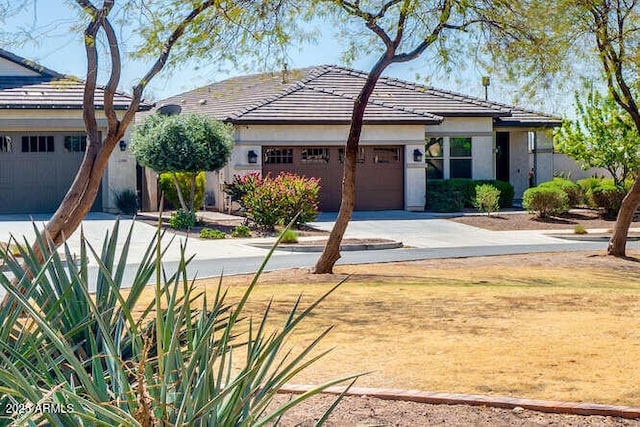 2185 N Beverly Pl, Buckeye, AZ 85396 - view of front facade with a tiled roof, an attached garage, driveway, and stucco siding