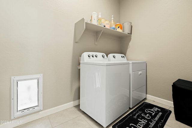 laundry area featuring washing machine and dryer and light tile patterned floors