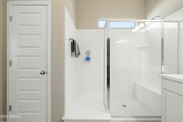 bathroom featuring vanity and a shower with door