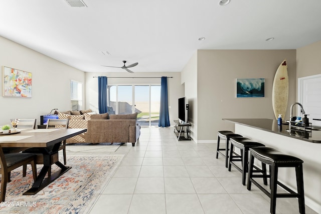 tiled living room featuring ceiling fan and sink