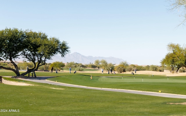 surrounding community with a lawn and a mountain view