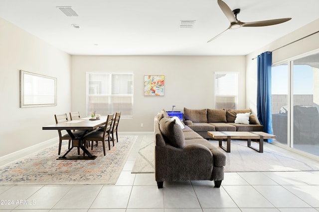 tiled living room with a wealth of natural light and ceiling fan