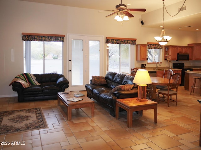 living area with a wealth of natural light, visible vents, and stone tile floors