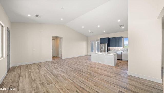 unfurnished living room with vaulted ceiling and light wood-type flooring