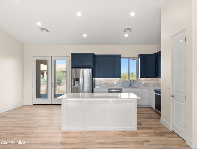 kitchen with a kitchen island, light hardwood / wood-style flooring, stainless steel appliances, and plenty of natural light