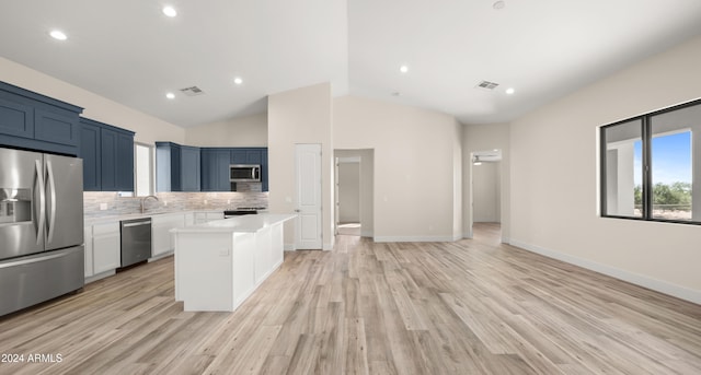 kitchen featuring decorative backsplash, light hardwood / wood-style flooring, stainless steel appliances, a center island, and blue cabinets