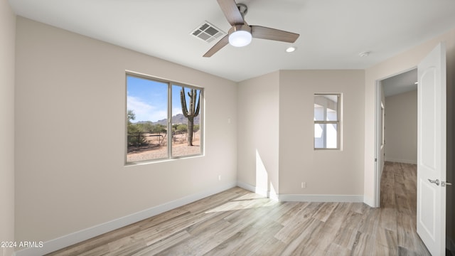 spare room with light wood-type flooring and ceiling fan