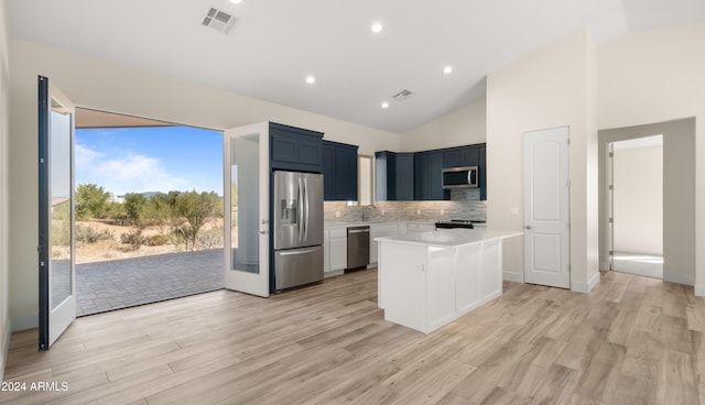 kitchen featuring backsplash, stainless steel appliances, light wood-type flooring, and a kitchen island