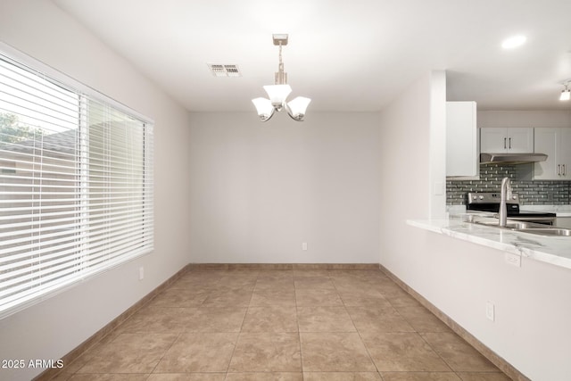 unfurnished dining area with a chandelier and light tile patterned flooring