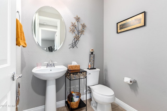 bathroom featuring tile patterned floors, toilet, and sink