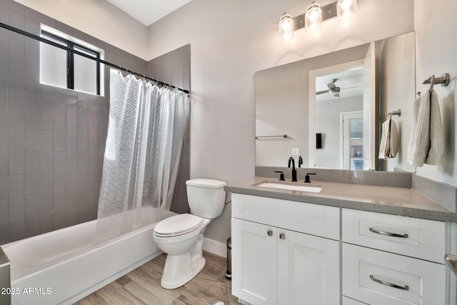 bathroom with toilet, ceiling fan, wood finished floors, shower / bath combo with shower curtain, and vanity