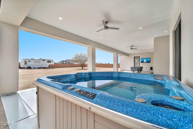 view of patio featuring fence private yard, a hot tub, and a ceiling fan