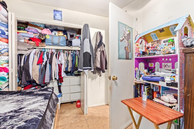 bedroom featuring tile flooring and a closet