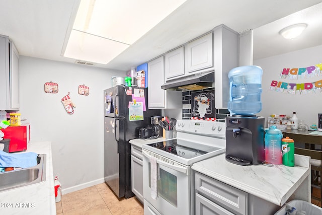 kitchen featuring light stone countertops, white electric stove, gray cabinets, black refrigerator, and light tile floors