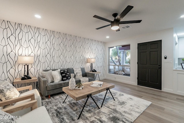 living room featuring ceiling fan and light hardwood / wood-style flooring