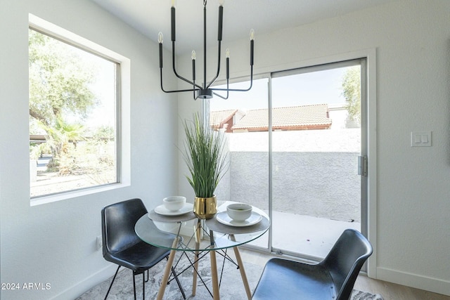 dining space with a notable chandelier, a healthy amount of sunlight, and light hardwood / wood-style floors