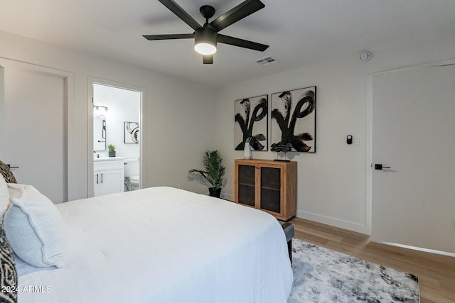 bedroom featuring ceiling fan, light hardwood / wood-style floors, and connected bathroom