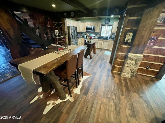 dining area with dark hardwood / wood-style flooring and beamed ceiling