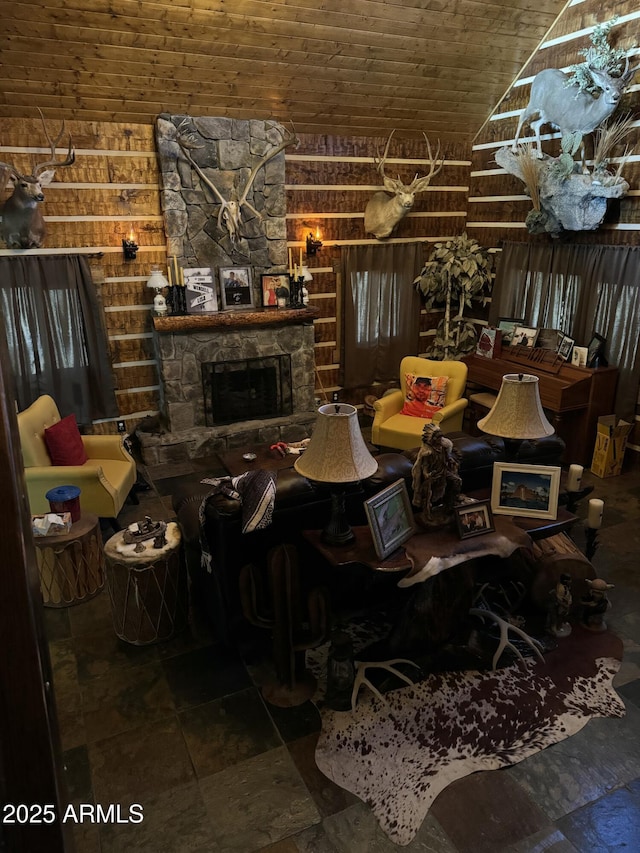 living room featuring a stone fireplace, lofted ceiling, and wood ceiling