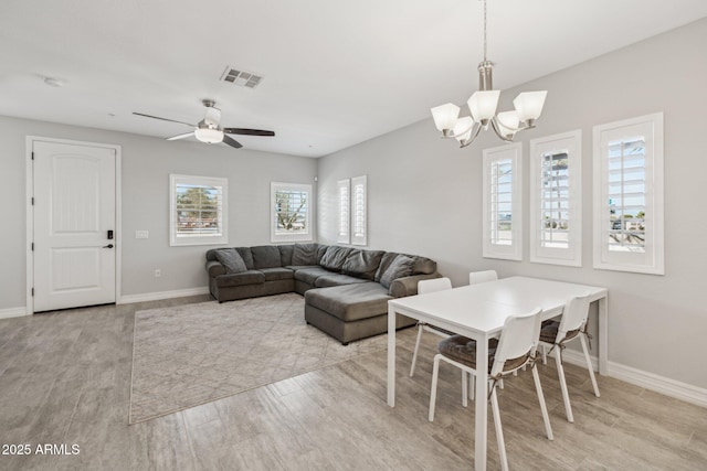 dining area featuring ceiling fan with notable chandelier and light hardwood / wood-style flooring