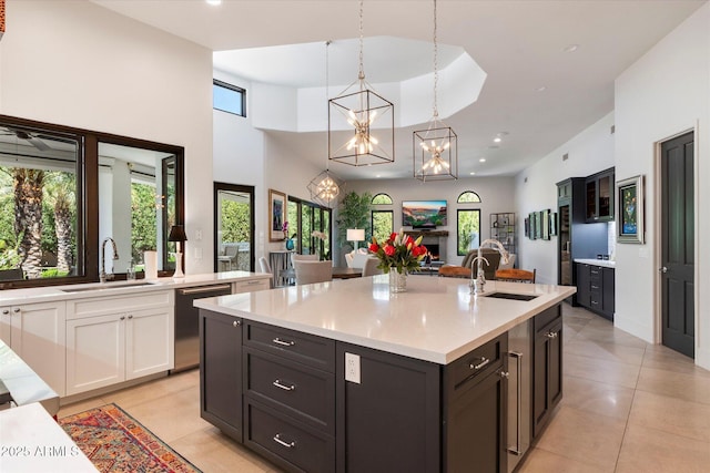 kitchen with stainless steel dishwasher, white cabinets, a fireplace, and a sink